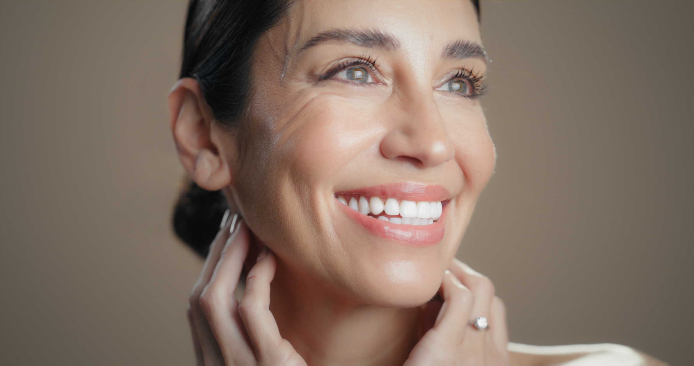 Schöne, lachende Frau, mit frischem Aussehen, nach einer Anti-Aging Gesichtsbehandlung